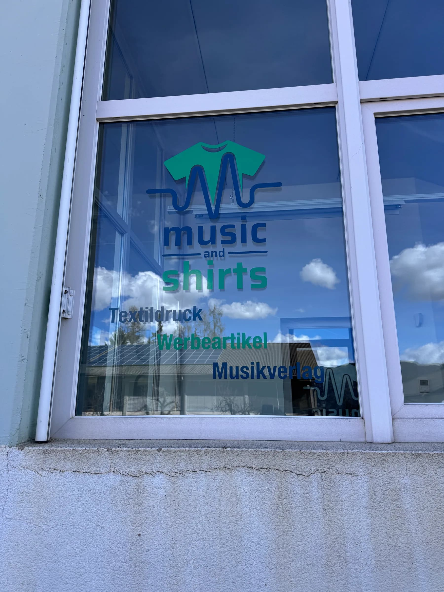 Schaufenster von Music and Shirts mit mehrfarbiger Beschriftung