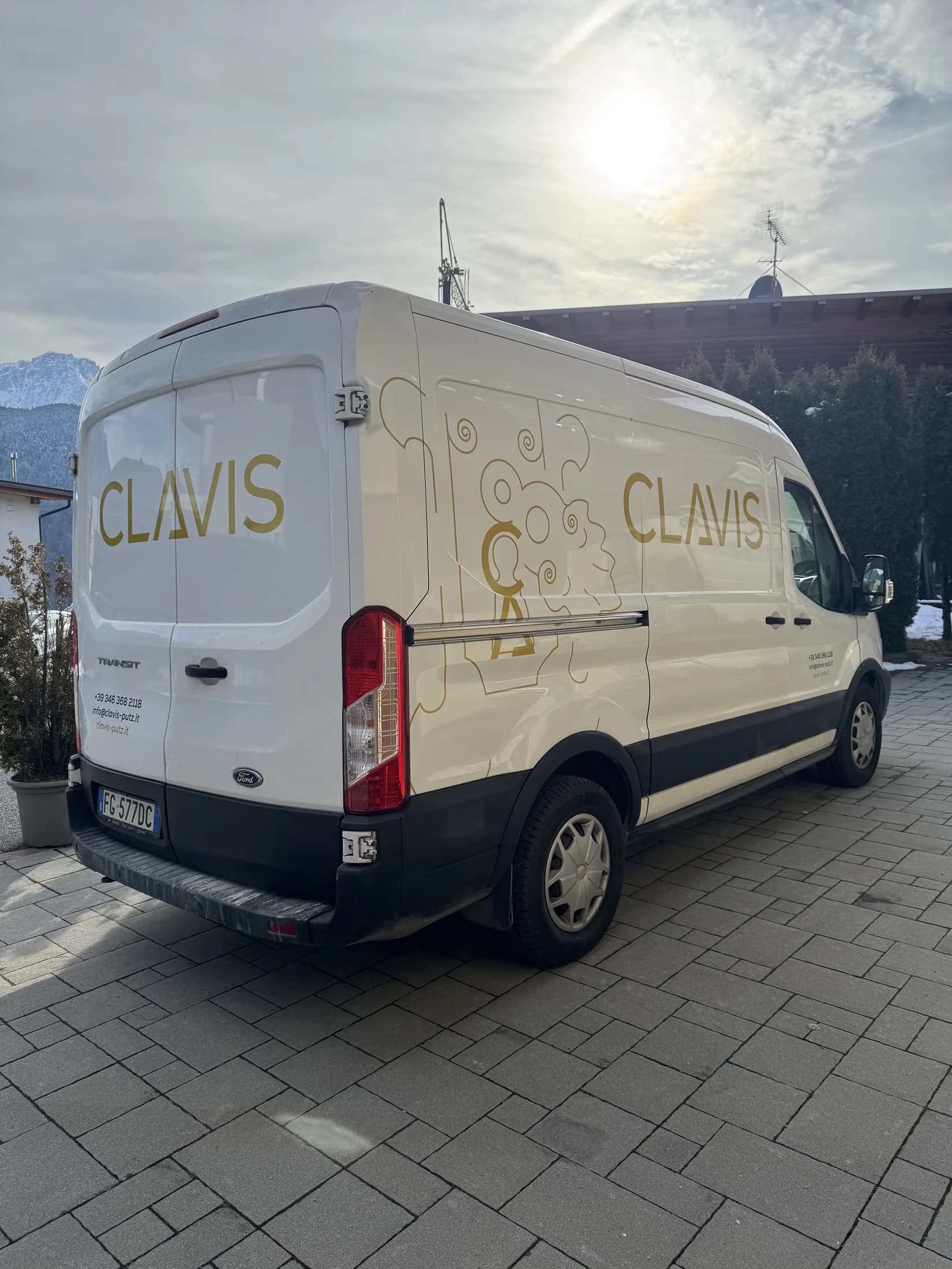 Weißer Clavis Transporter mit goldener Liniengrafik und Fahrzeugbeschriftung